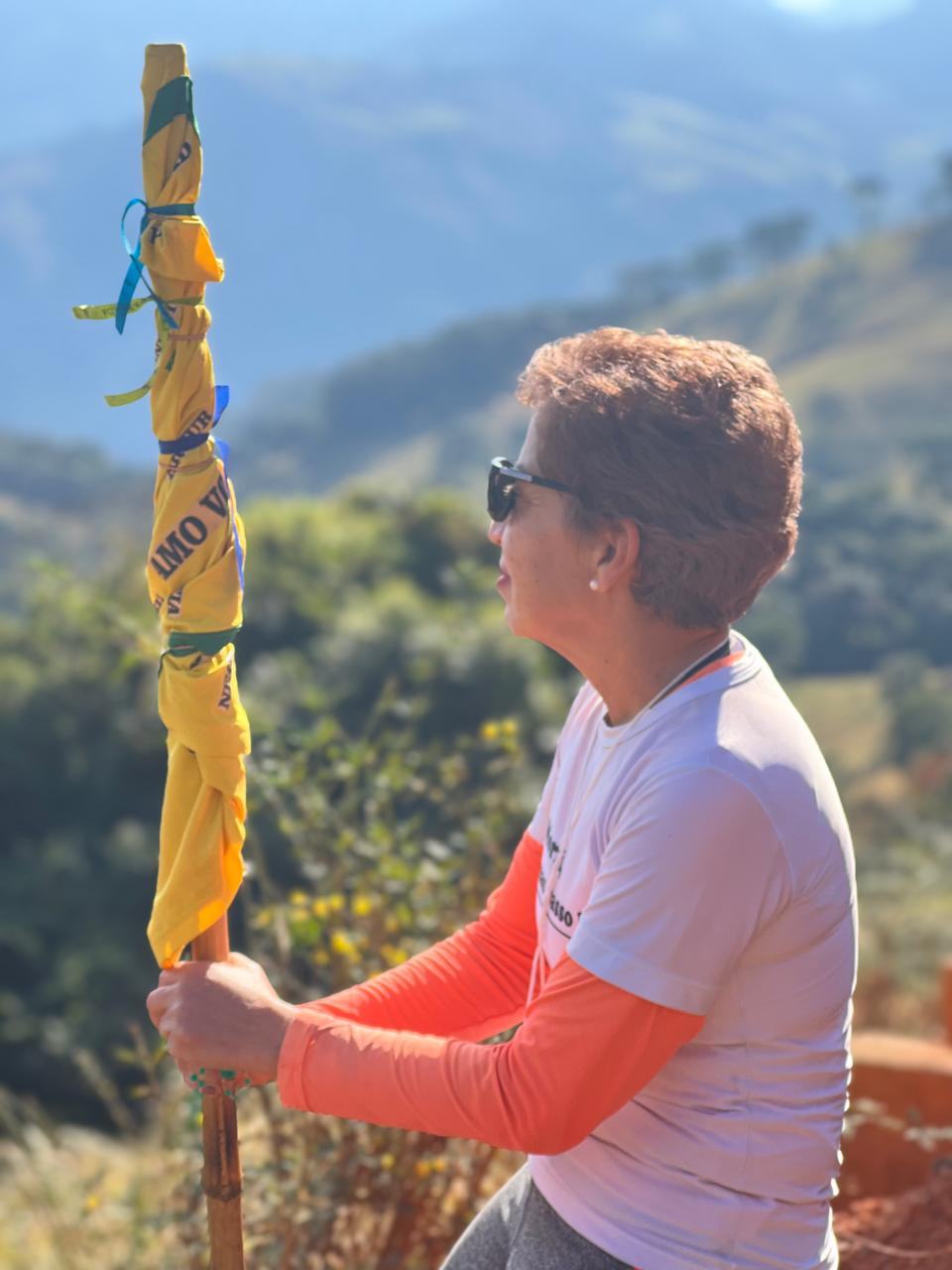 Graça em peregrinação nas montanhas segurando um cajado